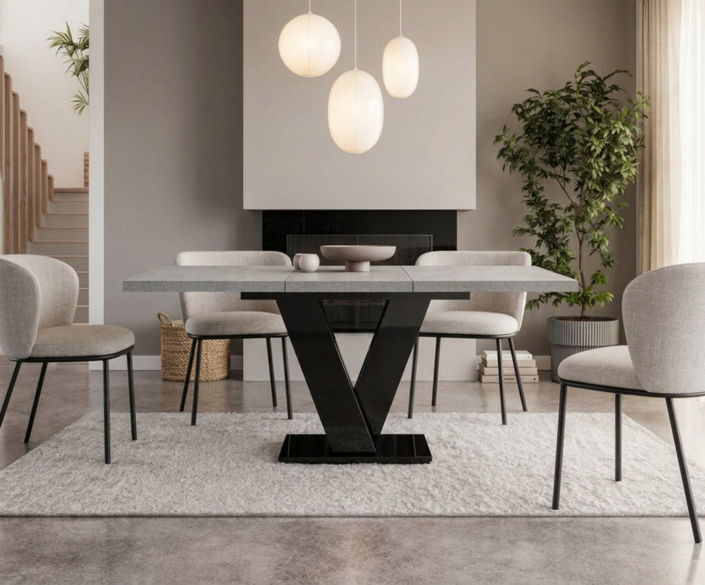 Extended grey concrete dining table with black V-shaped base, seating up to six