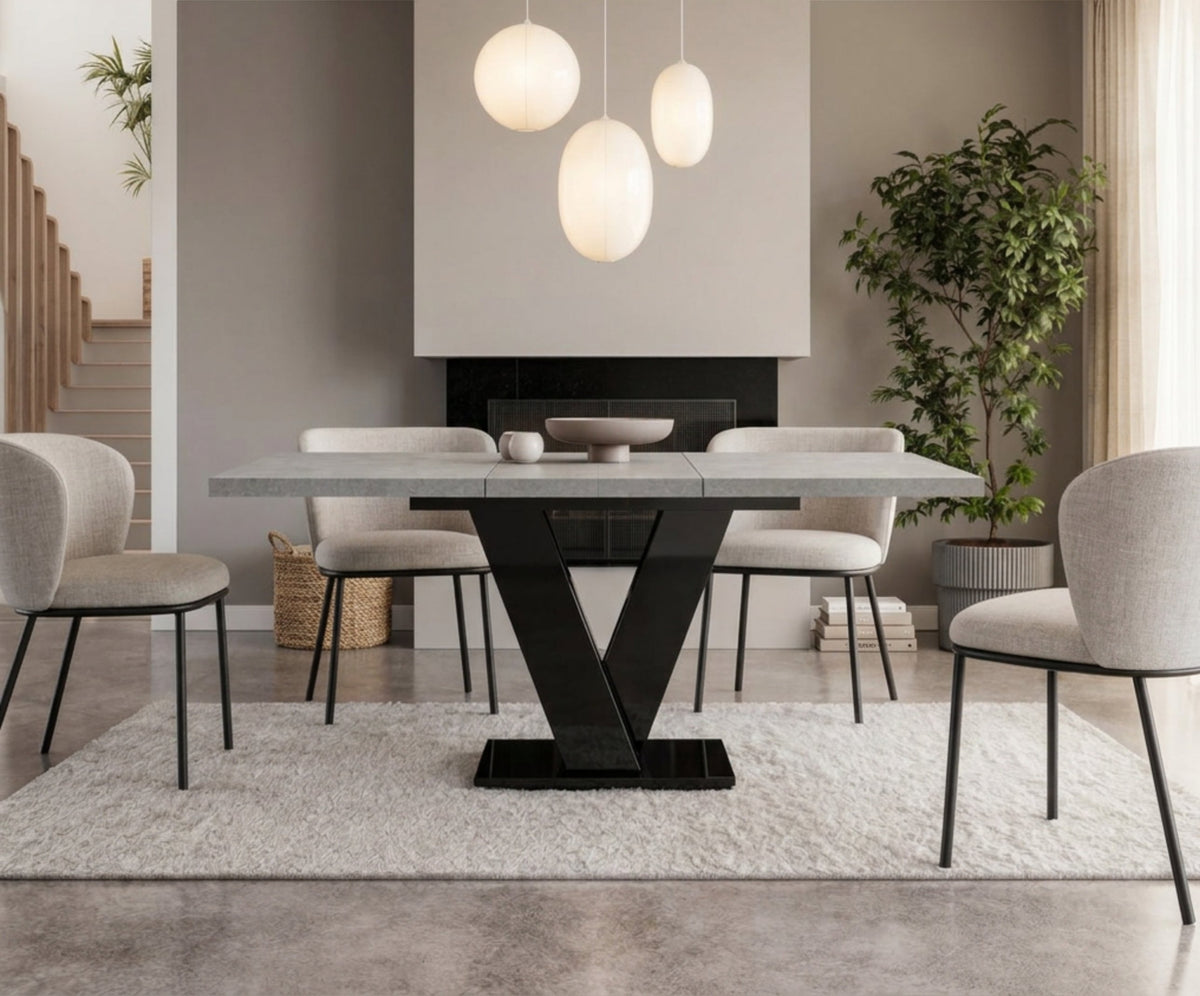 Extended grey concrete dining table with black V-shaped base, seating up to six