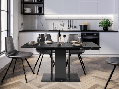 Modern extending dining table with black marble effect surface and narrow pedestal columns in a contemporary interior