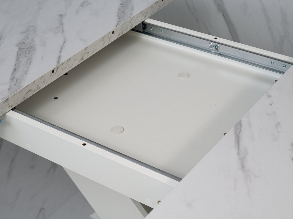 Detail of the extending table system concealed beneath the White Bianco marble effect top