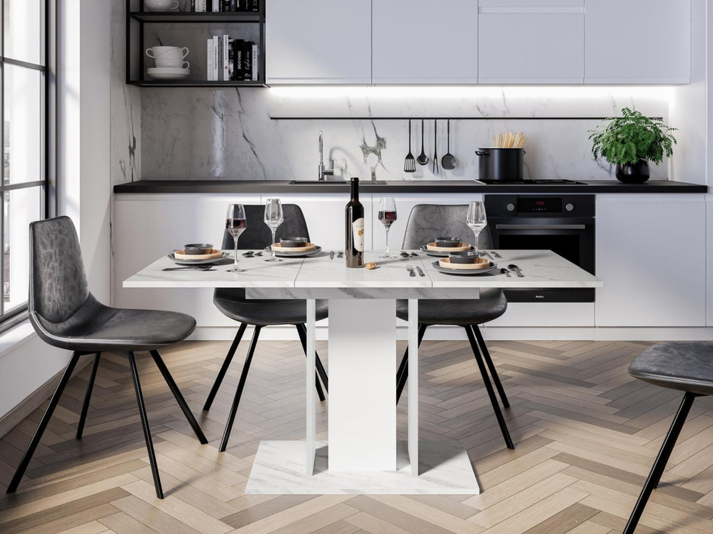 Modern extending dining table with White Bianco marble effect top and white pedestal columns in a bright dining space

