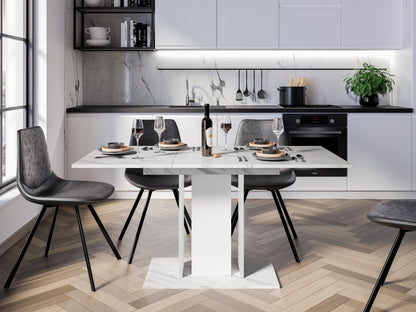 Modern extending dining table with White Bianco marble effect top and white pedestal columns in a bright dining space
