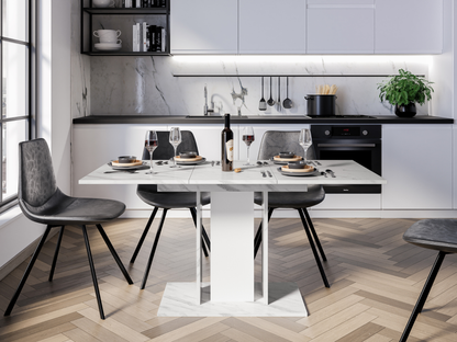 Modern extending dining table with White Bianco marble effect top and white pedestal columns in a bright dining space