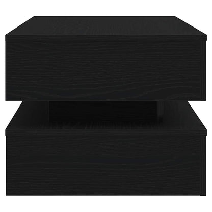 Small black side table with layered shelves and modern rectangular design, ideal beside a sofa.