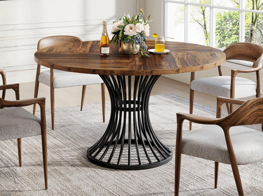 Round dining table with solid wood top and black metal pedestal base in modern dining room, small kitchen table with upholstered chairs
