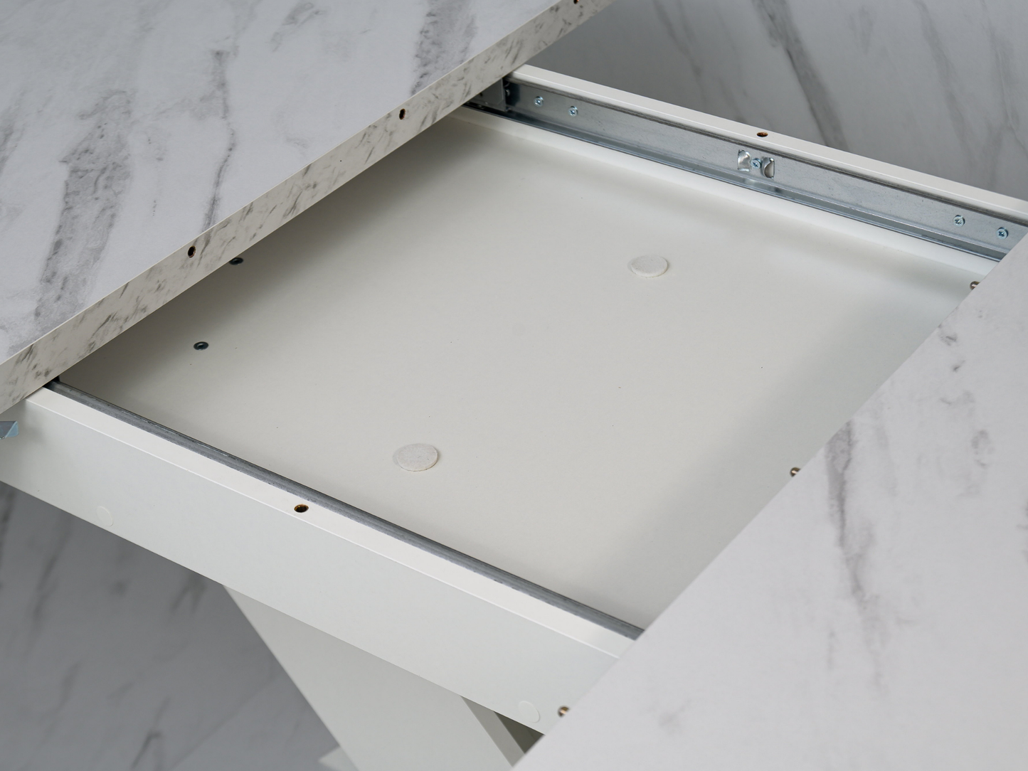 Detail of the extension system beneath the White Bianco marble effect tabletop of the dining table