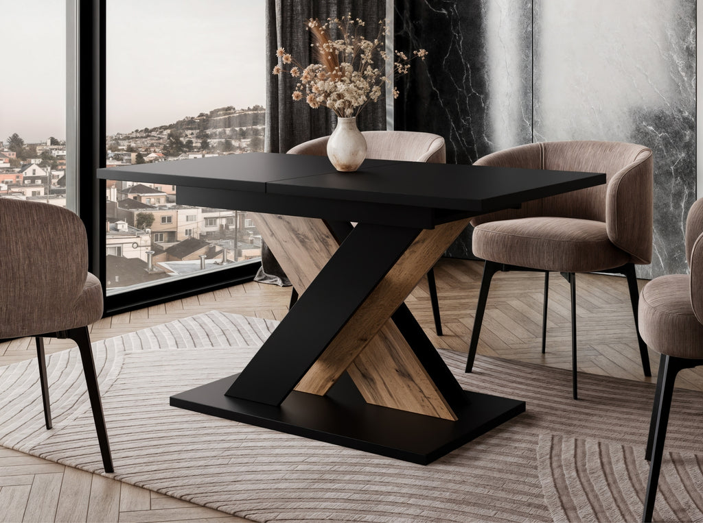 TOXX extending dining table with a black tabletop and wotan oak effect X-shaped base placed in a modern dining room setting, upholstered dining chairs arranged around the table on a rug.