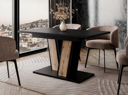 Muss extending dining table placed in a modern dining room setting, black tabletop with wotan oak effect base, surrounded by upholstered chairs and positioned on a decorative rug.